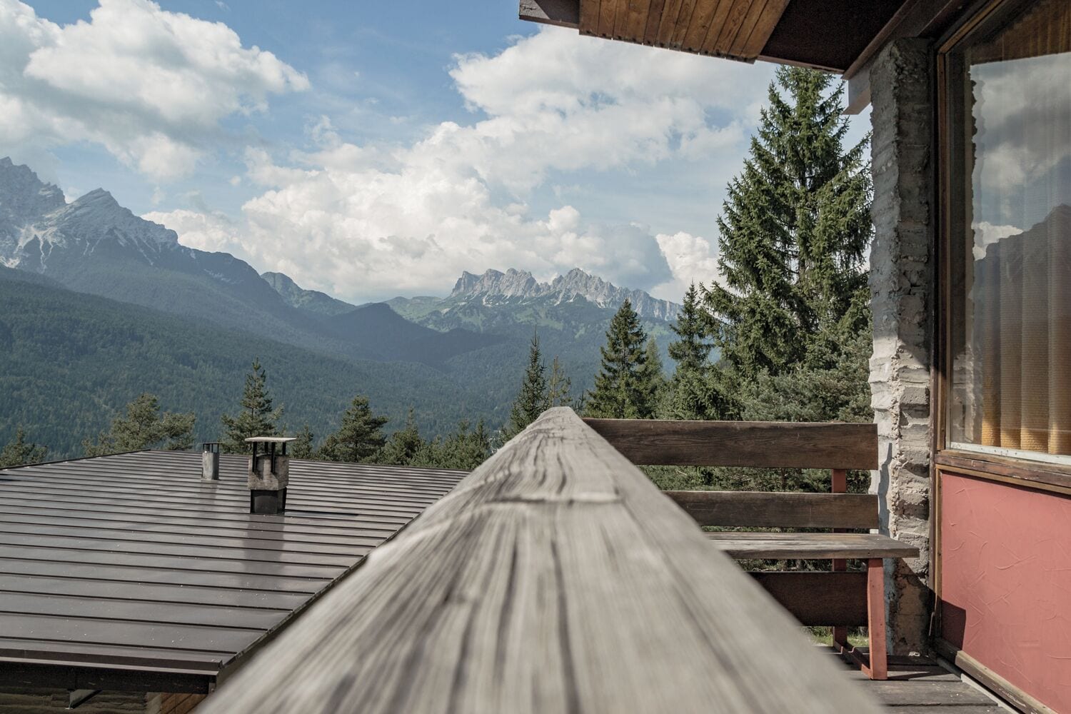 Une terrasse en bois offrant une vue sur une chaîne de montagnes.