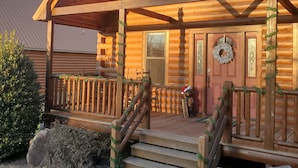 A log cabin with a porch, steps, and a wreath on the door. - Easy Drive Resort Cabin w/ Hot Tub, Mtn View, and Resort Pool Near National Park (Gatlinburg)
