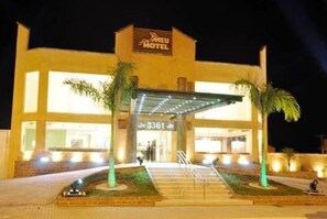 Entrada de un hotel con un letrero que dice "MEU HOTEL" y el número "3361" sobre la puerta.