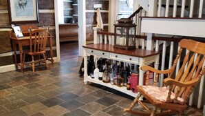 A spacious room with a wooden floor, a staircase, and a bookshelf. - The Cozy Canadian Lake House (Dysart et al,)