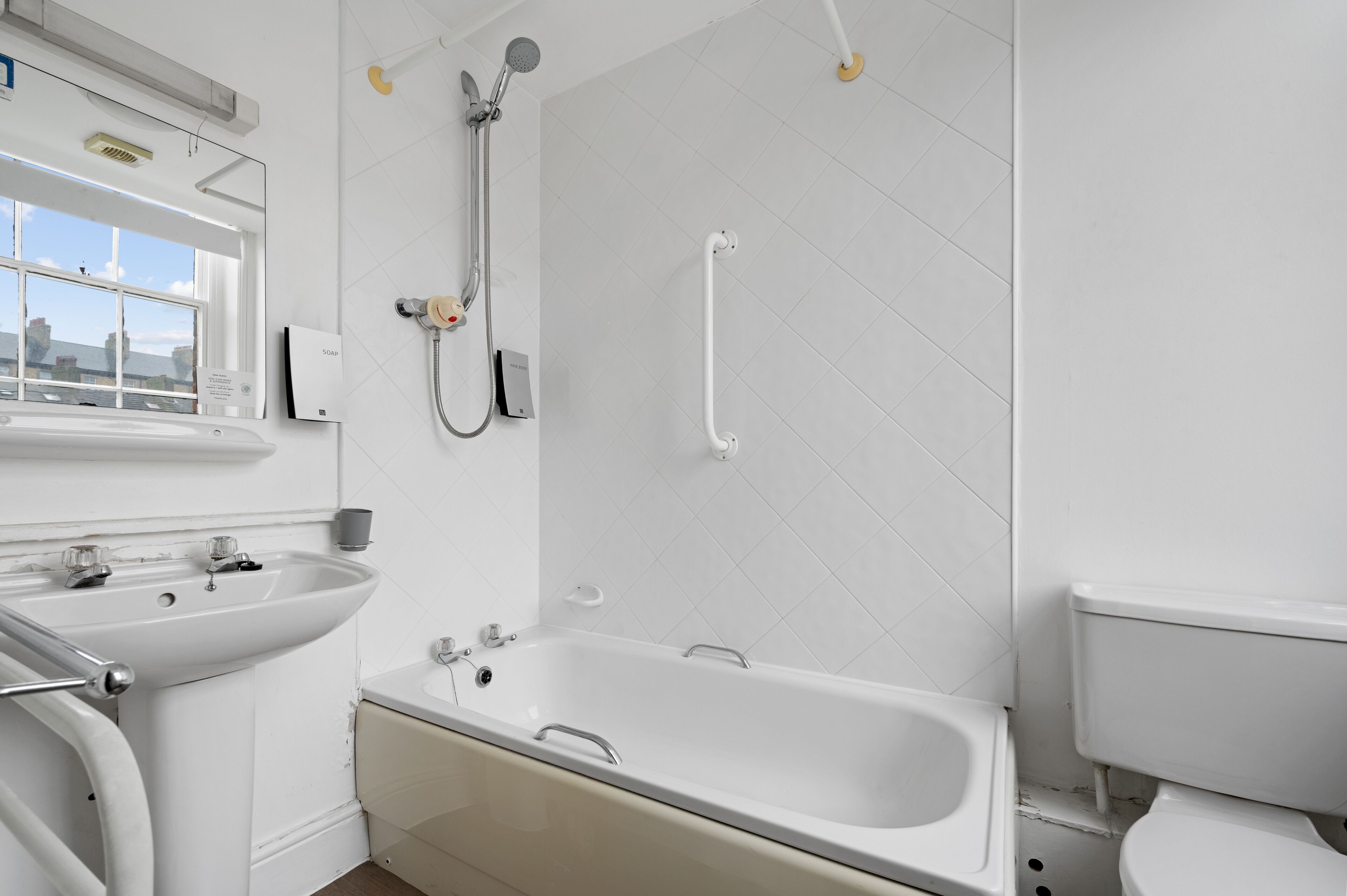 Een moderne badkamer met een badkuip, wastafel en toilet.