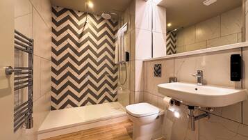 A modern bathroom with a shower, toilet, and sink.
