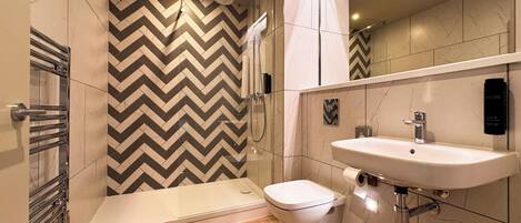 Un baño moderno con ducha, inodoro y lavabo.