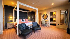 A four-poster bed with a headboard, a desk with a chair, a round mirror, and a wardrobe.