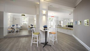A spacious hotel lobby with a central seating area, a reception desk, and a large mirror reflecting the space. - The Caledonian Torbay Hotel (Torquay)