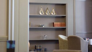 A modern interior with a bookshelf, a chandelier, and comfortable seating. - The Caledonian Torbay Hotel (Torquay)