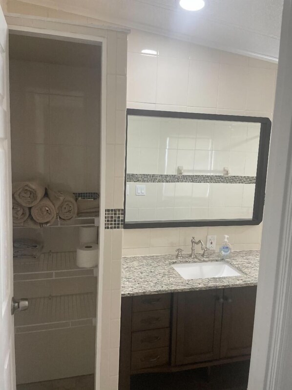 A bathroom with a large mirror, a sink, and a towel rack with towels. - Comfortable Okeechobee Home Minutes From Scott Driver, Okee-Tantie Boat Ramp (Okeechobee)