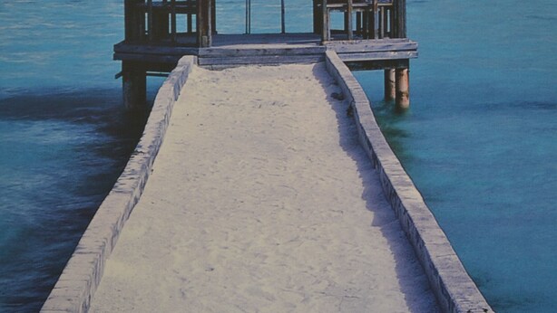 A thatched-roof structure on a pier extending into clear blue water. - Penthouse Himmelreich spacious 155 m² maisonette with fireplace & air conditioning (Senftenberg)