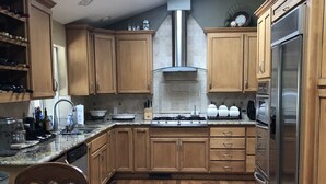 A modern kitchen with wooden cabinets, a stainless steel refrigerator, and a skylight. - On the Golf Course Home w amazing views!  (San Jose)