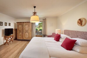 Habitación de hotel con una cama grande, televisor, armario y vistas al exterior.