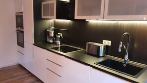 A modern kitchen with a built-in oven, a coffee maker, a toaster, and a sink. - Gute Laune Hof Klingenthal (Klingenthal)