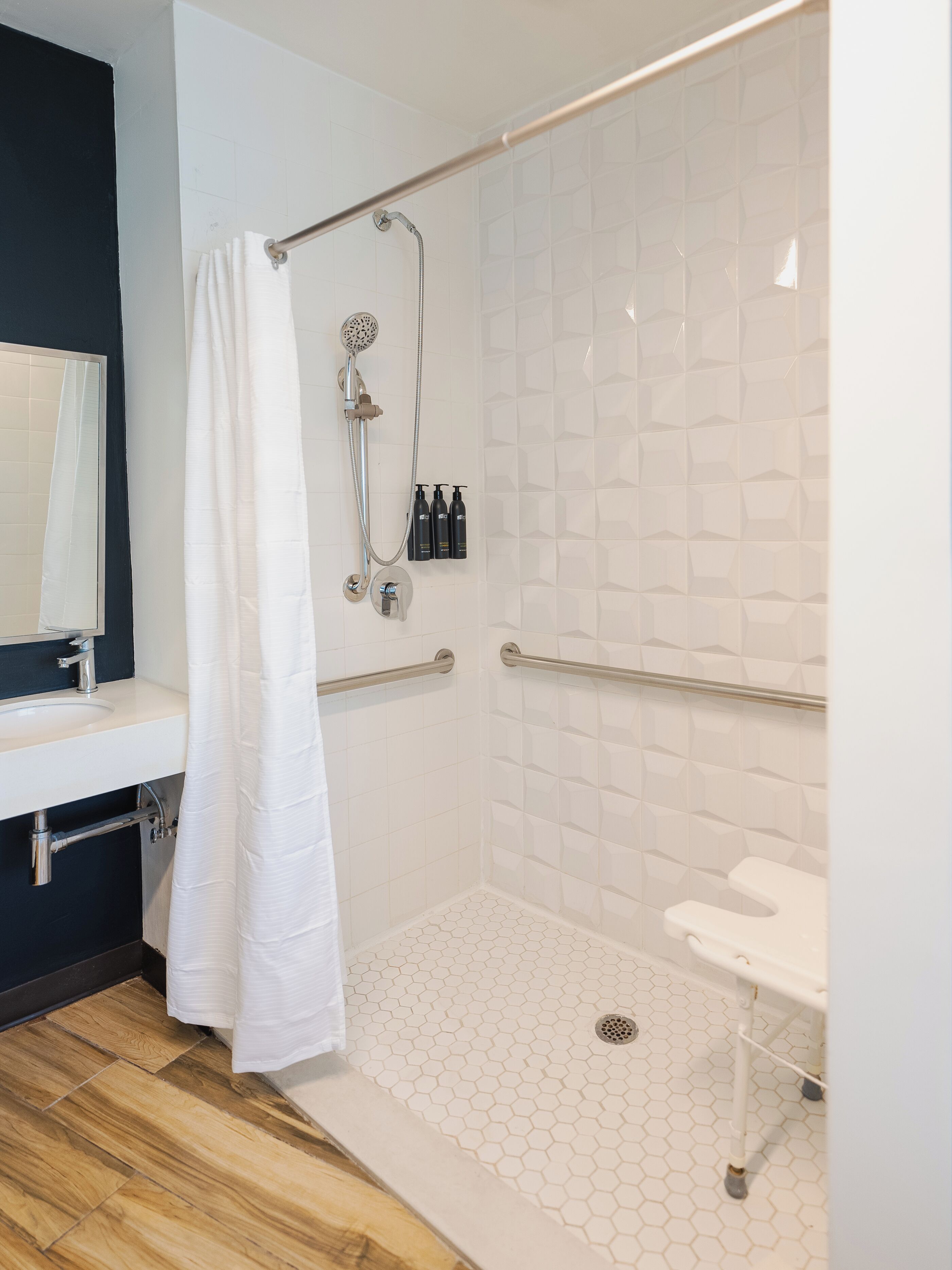 Een moderne badkamer met douche, toilet en wastafel.