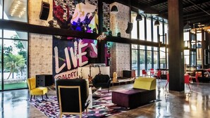 A spacious lobby with a large wall mural, comfortable seating, and large windows.