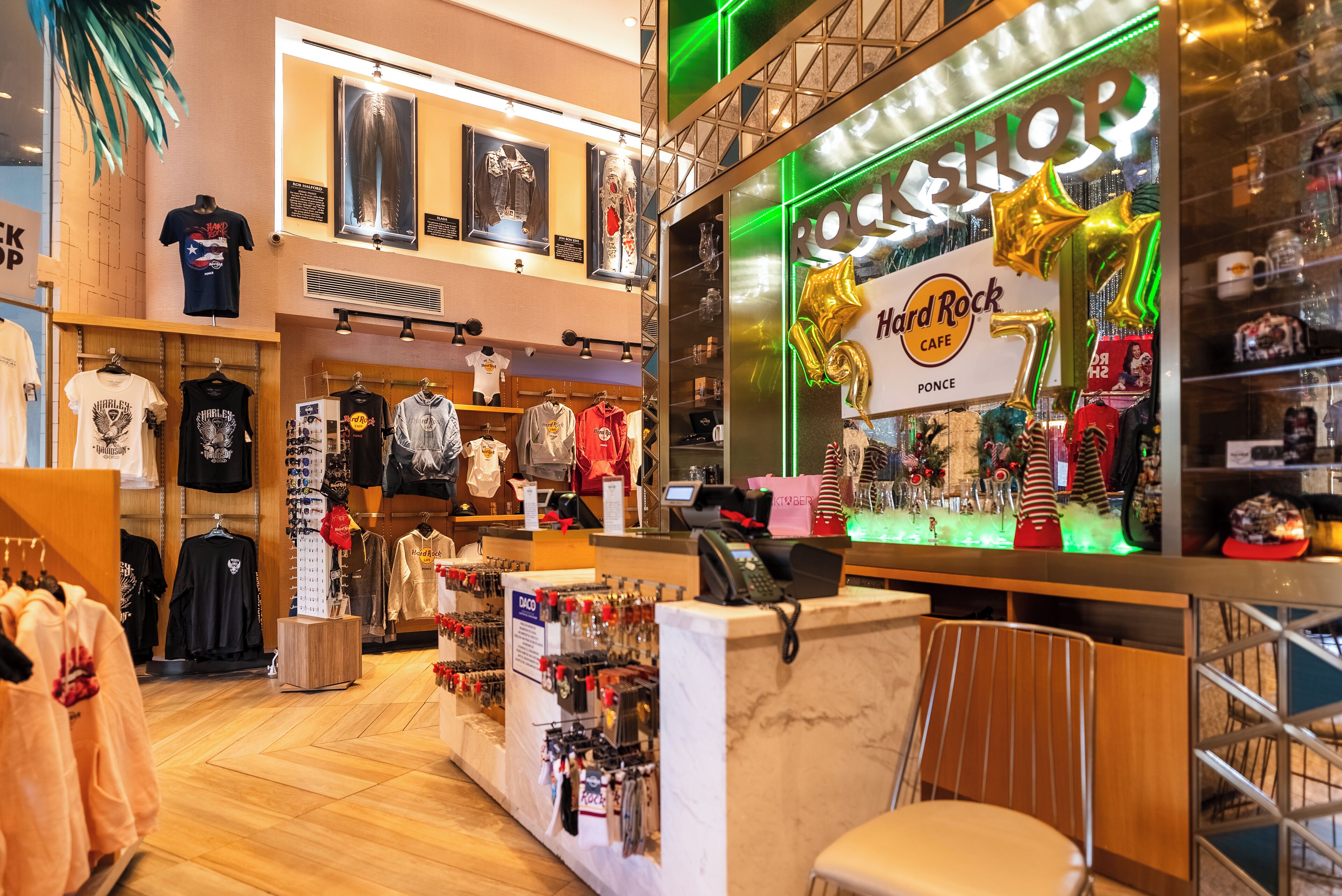 Un restaurant Hard Rock Cafe doté d’un comptoir, de présentoirs à vêtements et d’un espace dédié à la vente de produits dérivés.