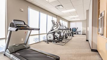 A gym with treadmills, elliptical machines, and stationary bikes.