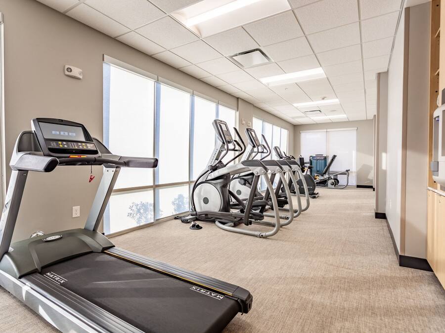 A gym with treadmills, elliptical machines, and stationary bikes.