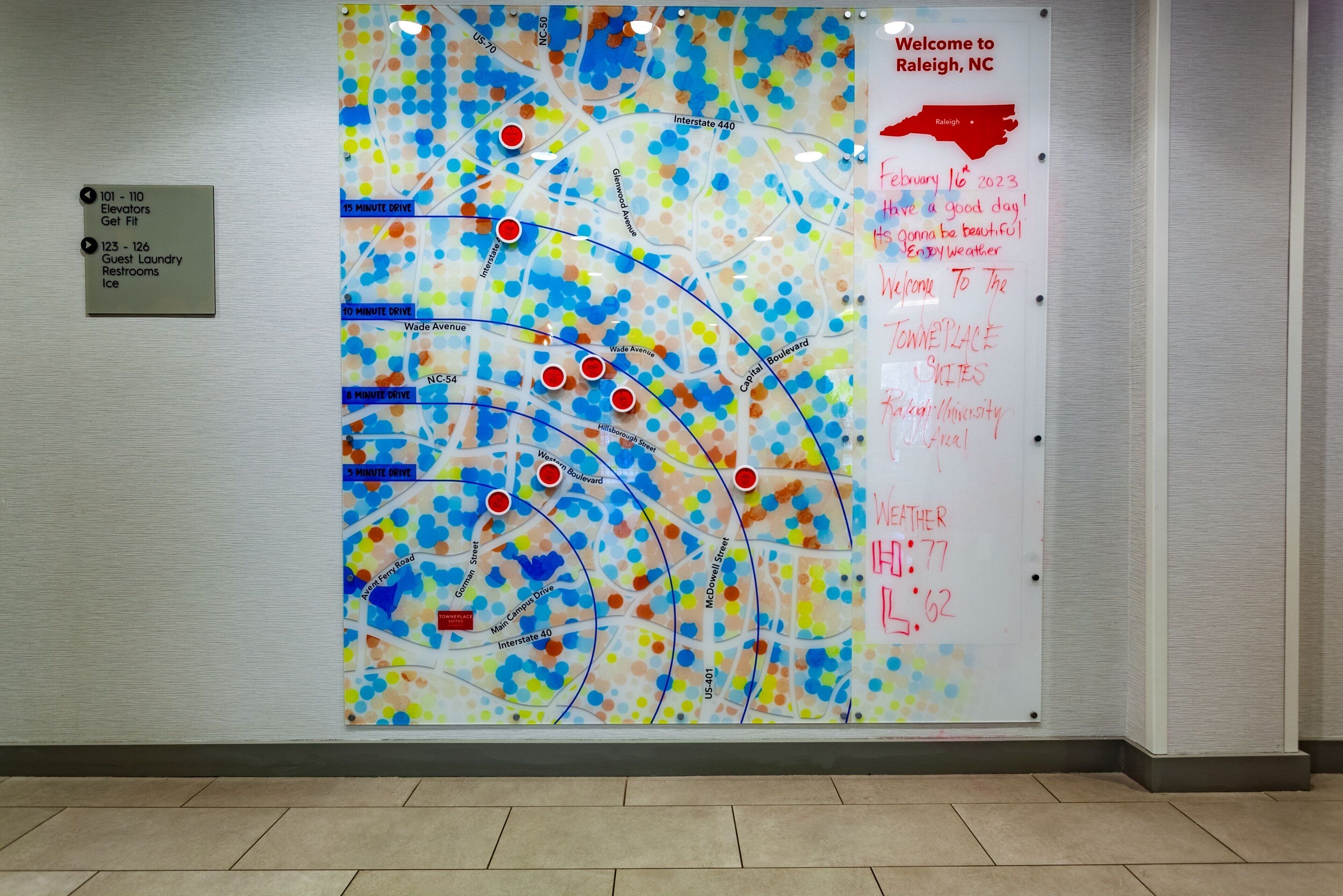 Un mapa de Raleigh, Carolina del Norte, con un mensaje de bienvenida y un cartel que indica los servicios para huéspedes.