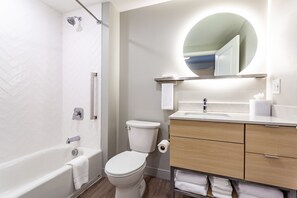 Een bad/douchecombinatie, een haardroger, handdoeken