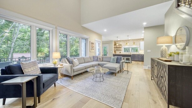 A spacious living room with a large sectional sofa, a coffee table, and a dining area with a kitchen in the background. - High-End Modern Farmhouse Relaxation in Saugatuck - Close to Downtown (Saugatuck)