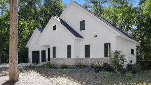 A modern two-story house with a white exterior, multiple windows, and a sloped roof. - High-End Modern Farmhouse Relaxation in Saugatuck - Close to Downtown (Saugatuck)