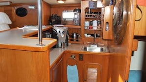 A compact galley with a sink, stove, and storage cabinets. - Beautiful 72 foot sailing yacht. Explore the Sea of Cortez in style.  (La Paz)