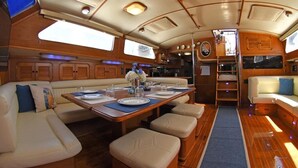A boat interior with a dining area, seating, and a kitchen. - Beautiful 72 foot sailing yacht. Explore the Sea of Cortez in style.  (La Paz)