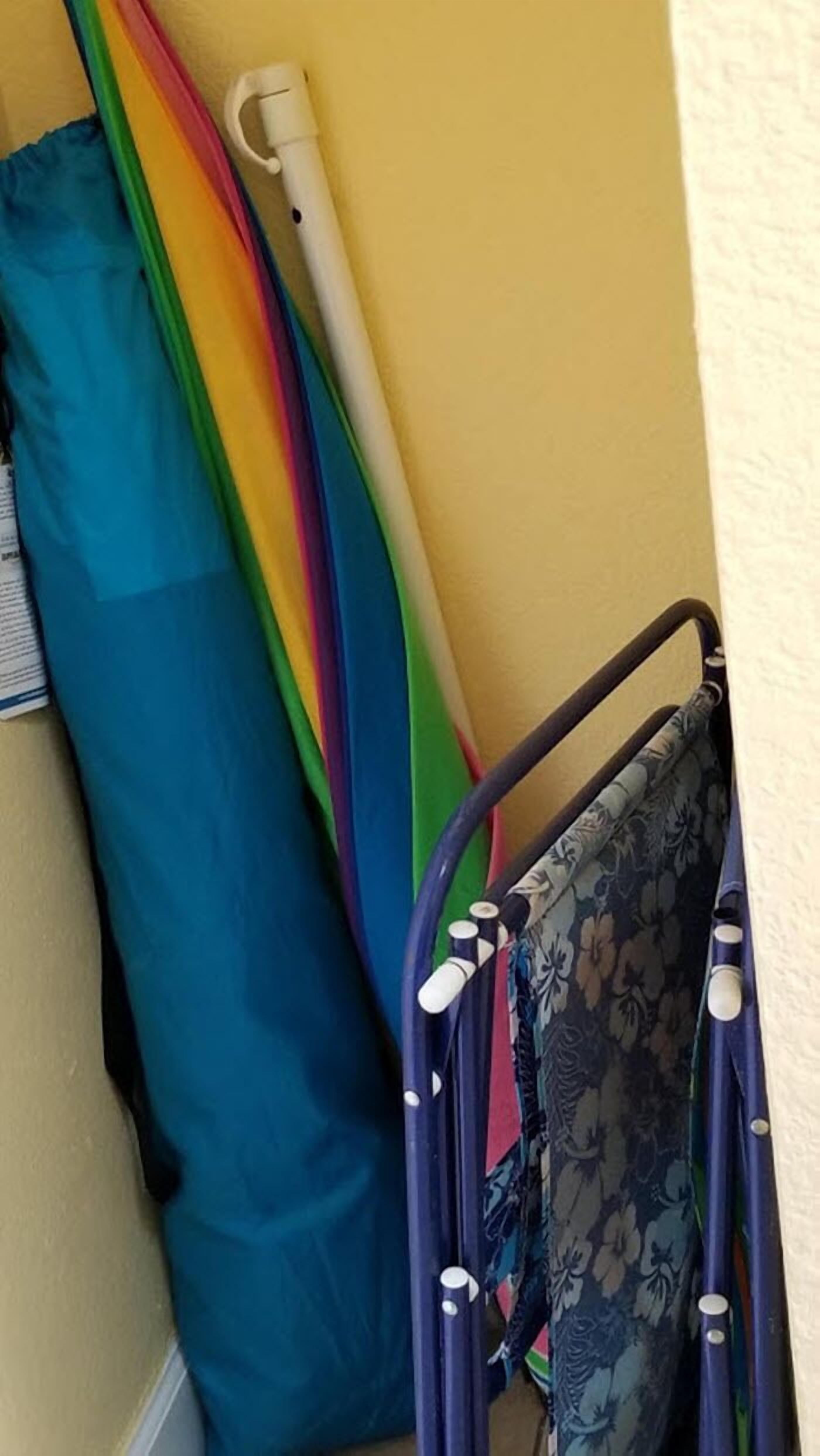 A corner of a room with a blue curtain, a white umbrella, and a metal frame structure.