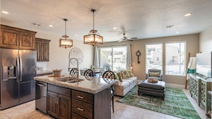 A spacious kitchen with granite countertops, a built-in refrigerator, and wooden cabinets.