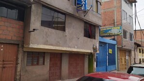 Un edificio de dos pisos con un cartel que dice 'HOSPEDAL' en el piso superior.