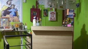 Una habitación con una pared verde, una encimera de madera, un banco rojo y un suelo de baldosas.