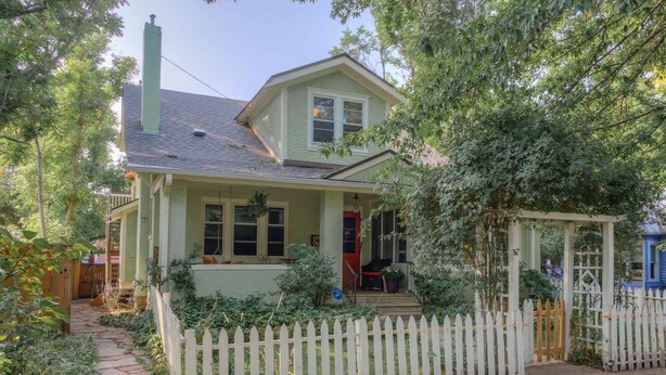 A two-story house with a porch, a white picket fence, and a garden area. - Downtown Delight off Pearl street (Boulder)