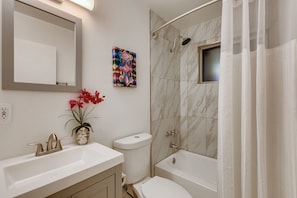 A modern bathroom with a large mirror, a toilet, a bathtub, and a shower. - Heatherbrae (Scottsdale)