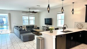 A modern kitchen with a central island, black cabinets, and a stainless steel dishwasher.