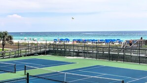 Ein Beachvolleyballfeld mit Blick auf das Meer und Strandstühle.