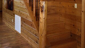 A wooden staircase with a railing, a wall-mounted light fixture, and a vent. - Rowdy Rooster, A Relaxing Cabin 3.4 miles from nearest Broken Bow Lake boat ramp (Broken Bow)