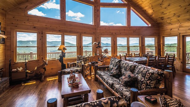 A spacious wooden cabin with large windows, a cozy seating area, and a view of the mountains. - A View  To Remember (Morganton)