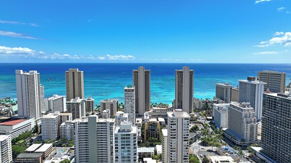 A high-rise hotel with a view of the ocean and other buildings.