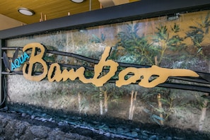 Welcome to AQUA Bamboo, where a pathway leads to a window offering a glimpse into the property.