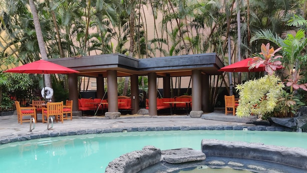A pool area with a hot tub, red umbrellas, and seating under a covered area. - 10th Floor Air Conditioned Apt in Central -Bamboo Waikiki 1005 (Honolulu)