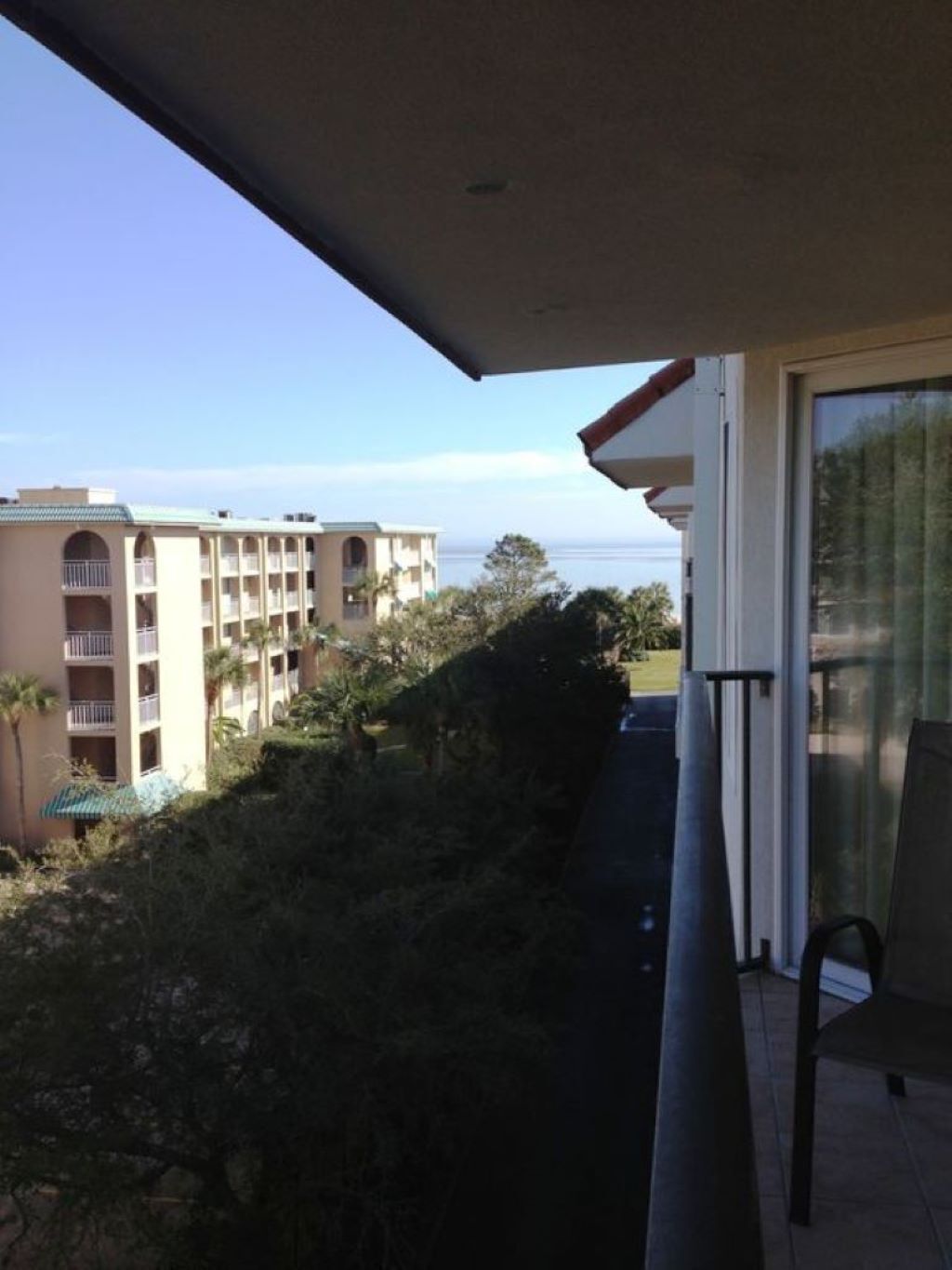 Un balcon donnant sur un immeuble et une étendue d’eau.