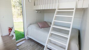 Dormitorio con literas, una escalera, una ventana y un extintor.