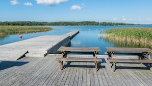 Un muelle de madera que se adentra en un lago tranquilo con cielos despejados.