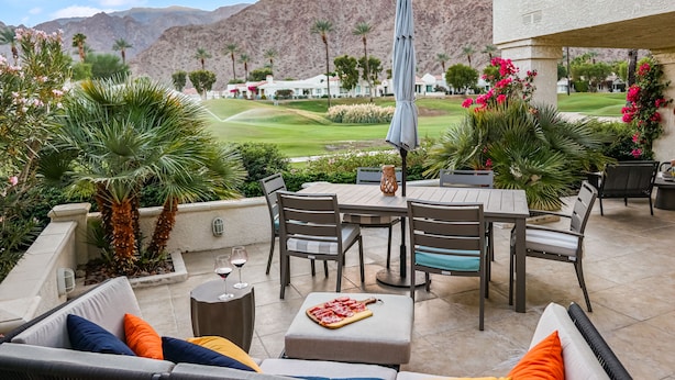 An outdoor patio with a dining table, chairs, and a pizza board. - Golf Course Retreat w/ Private Casita Steps to La Quinta Resort & Pools (La Quinta)