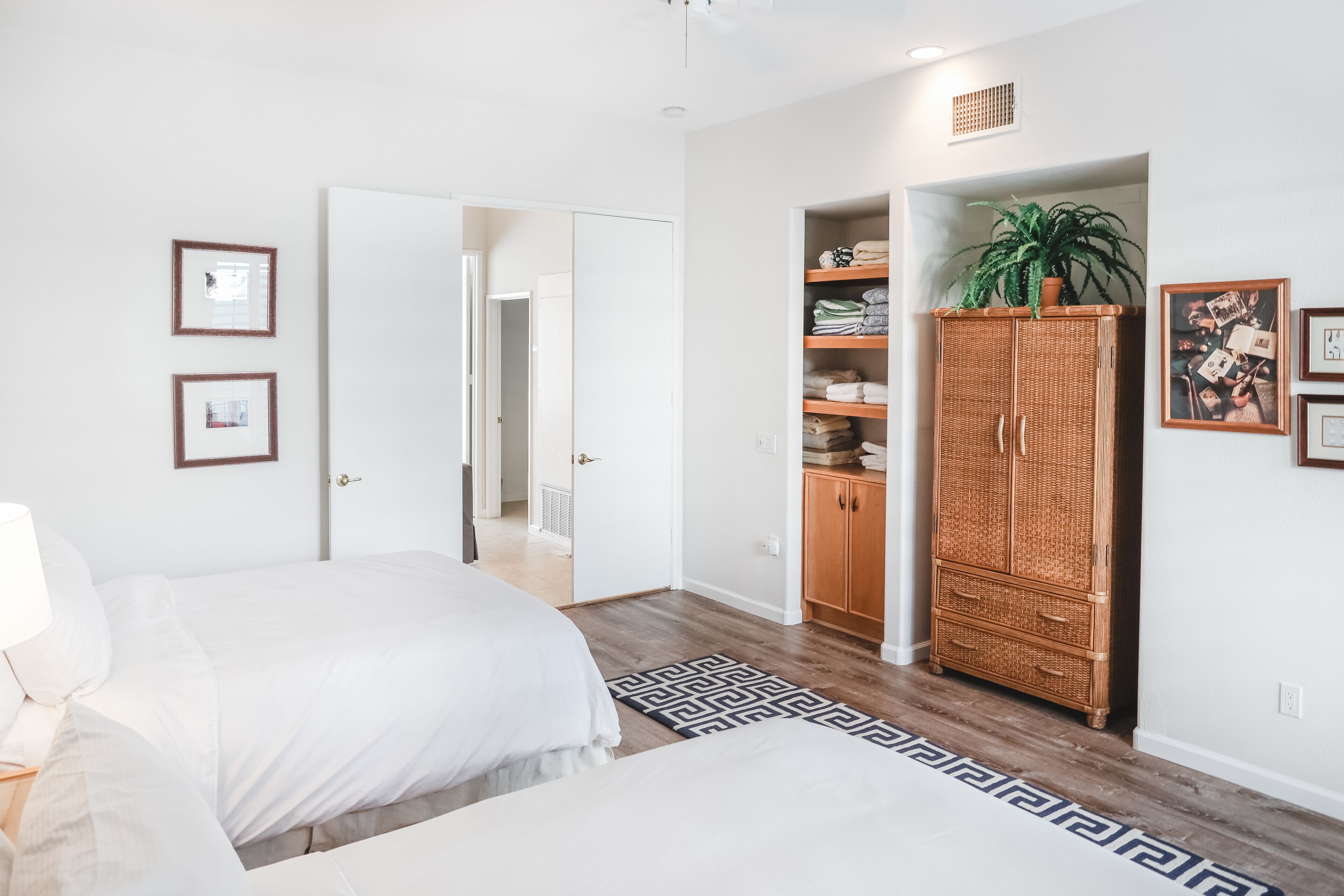 A bedroom with a bed, a wardrobe, and a door leading to another room.