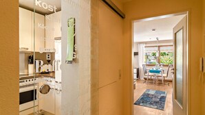 A modern kitchen with a built-in oven, a dining area with a table and chairs, and a view of the outdoors. - Comfortable 4-Star Vacation Apartment "Wolf" with Terrace, Grill & Wi-Fi (Überlingen)