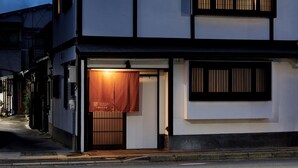 A traditional Japanese building with a wooden door and a sign above it.