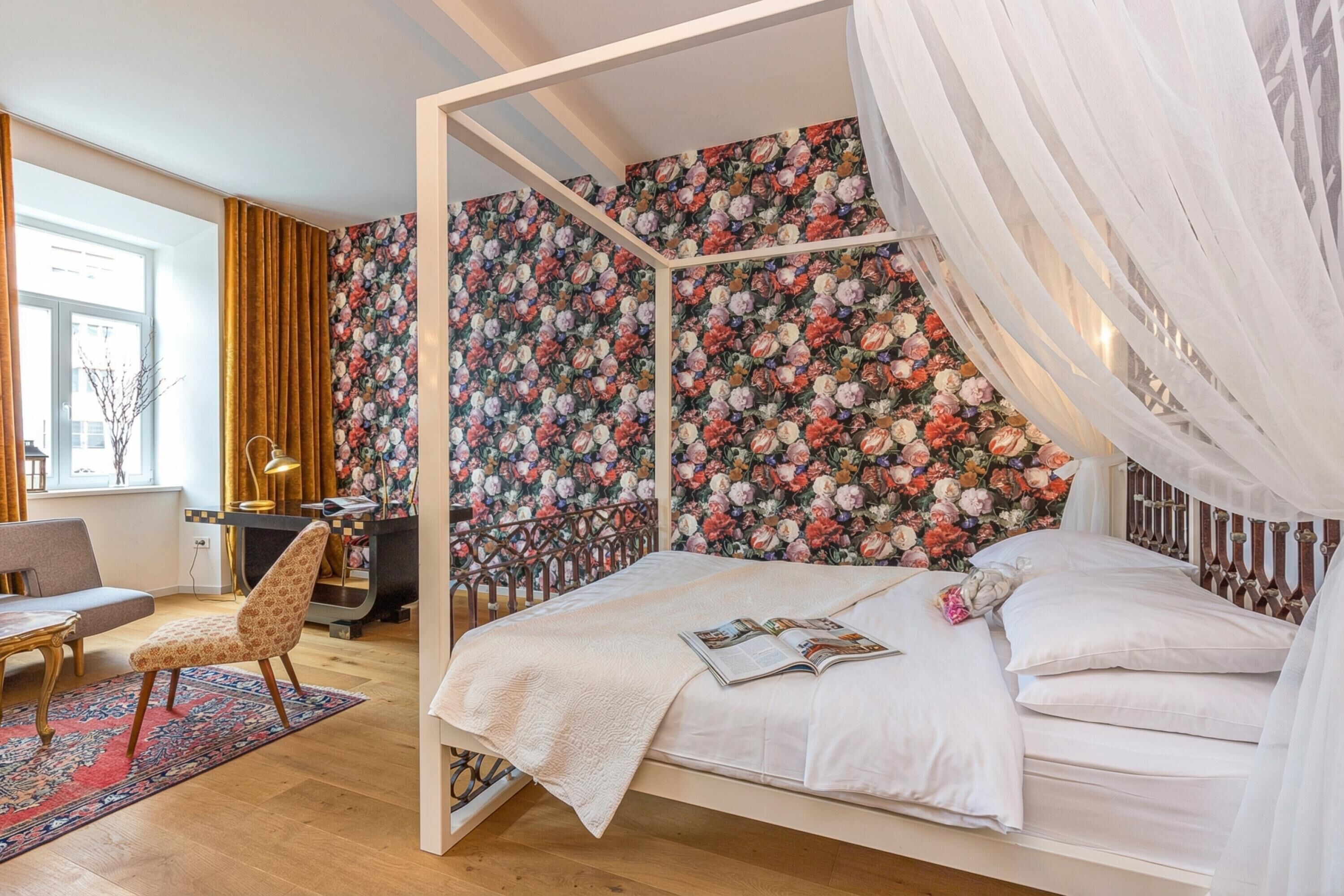 A bedroom with a four-poster bed, a desk, and a chair.
