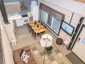 A compact living space with a kitchenette, dining area, and a TV.