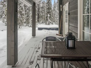 A wooden deck with a table and chairs, a bench, and a lantern.