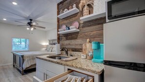 A compact kitchen with a microwave, a sink, and a countertop with a dish rack. - Greers Ferry Lakefront Getaway - easy lake access (Higden)